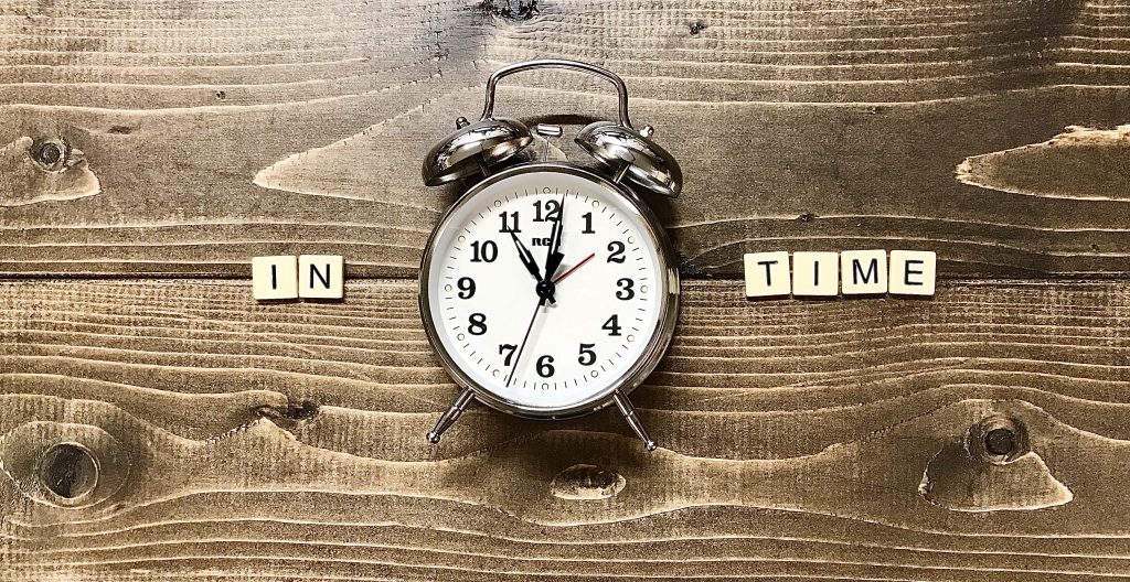 Clock with block letters "IN TIME"